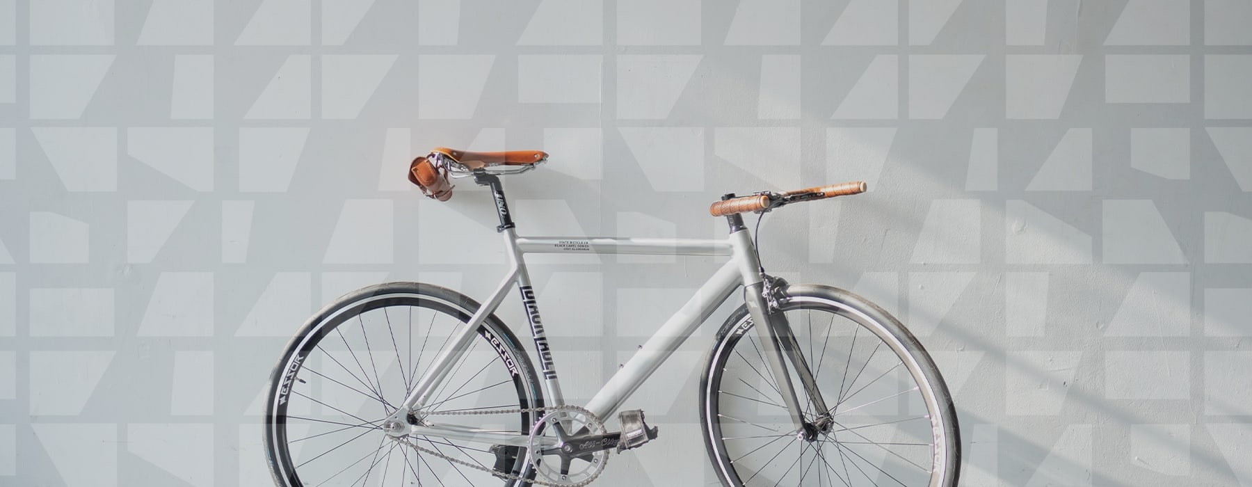 lifestyle image of a bicycle up against a white wall